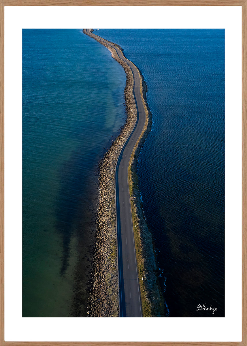 Vejdæmningen Langøre til Helnæs. Blot hav, lav sol. Vejen der snor sig gennem vandet.